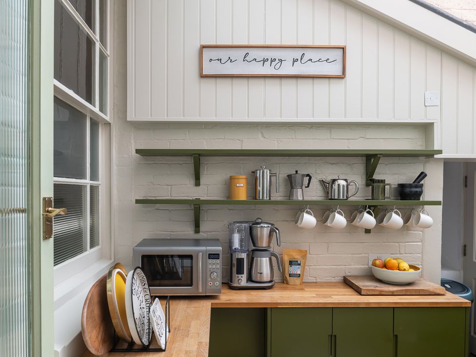 A kitchen with appliances and shelves at Astondene, East Cliff, Southwold