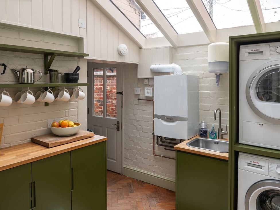 A kitchen with a sink and washing machine at Astondene, East Cliff, Southwold