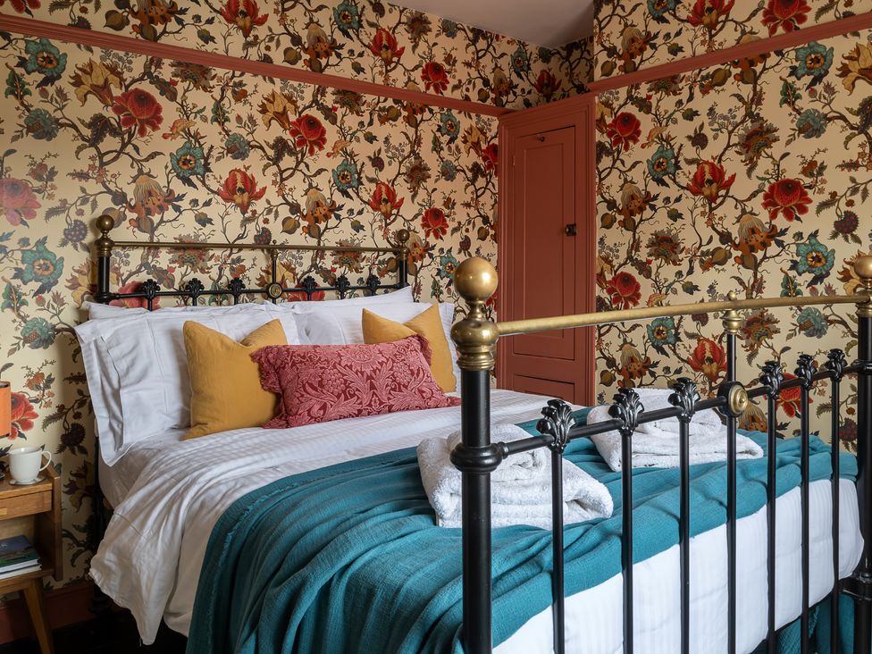 A bedroom with a bed and nightstand at Astondene, East Cliff, Southwold