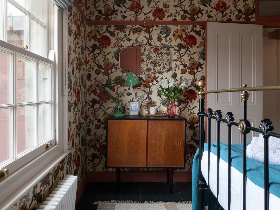 A bedroom with a bed and a nightstand at Astondene, East Cliff in Southwold