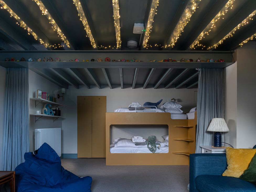 A bedroom with bunk beds and shelves at Astondene, East Cliff, Southwold
