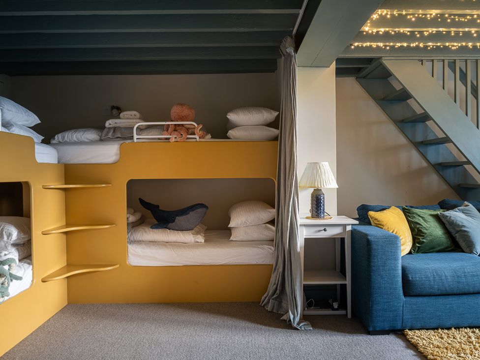 A bedroom featuring a bunk bed and a sofa at Astondene, East Cliff in Southwold
