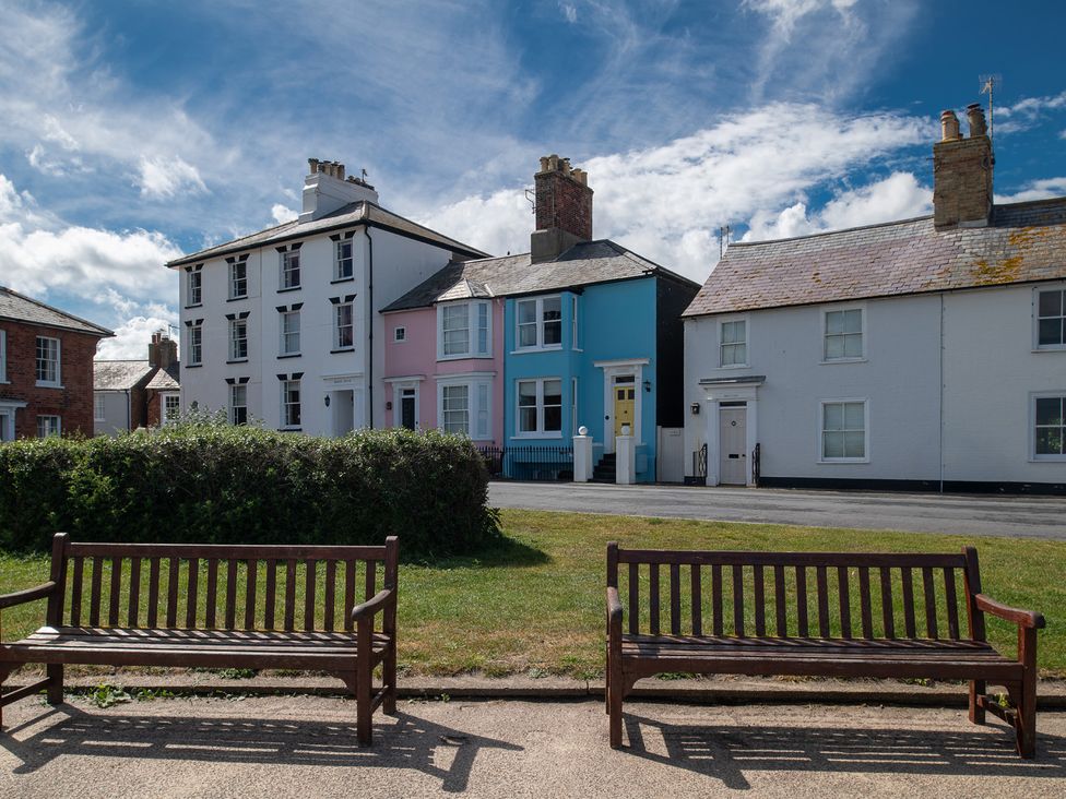 Houses with colorful exteriors and benches in front at Astondene, East Cliff in Southwold
