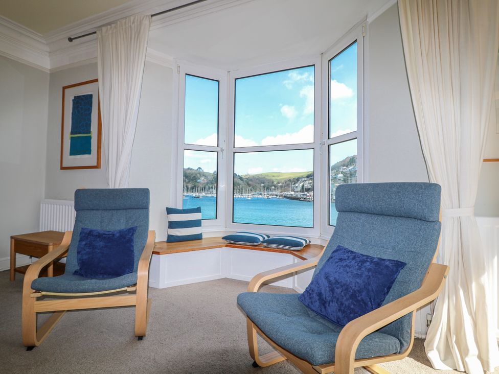 A living room with armchairs and a view of the harbor at Harbourside in Dartmouth