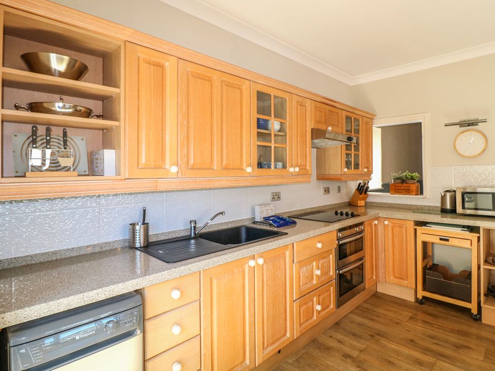 A kitchen with wooden cabinets and appliances at Harbourside in Dartmouth