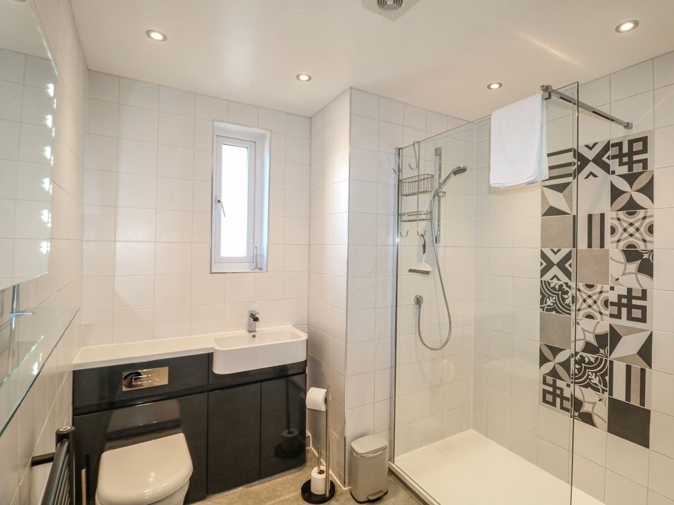 A bathroom featuring a shower, toilet, and sink at Harbourside in Dartmouth