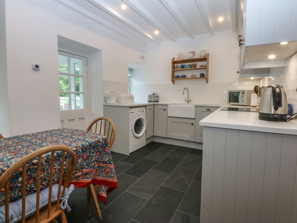 A kitchen with a table and appliances at Chandos in Dolwyddelan