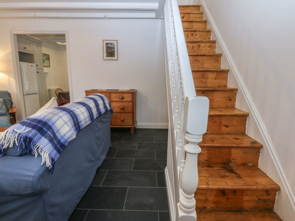 A living room with staircase and sofa at Chandos in Dolwyddelan