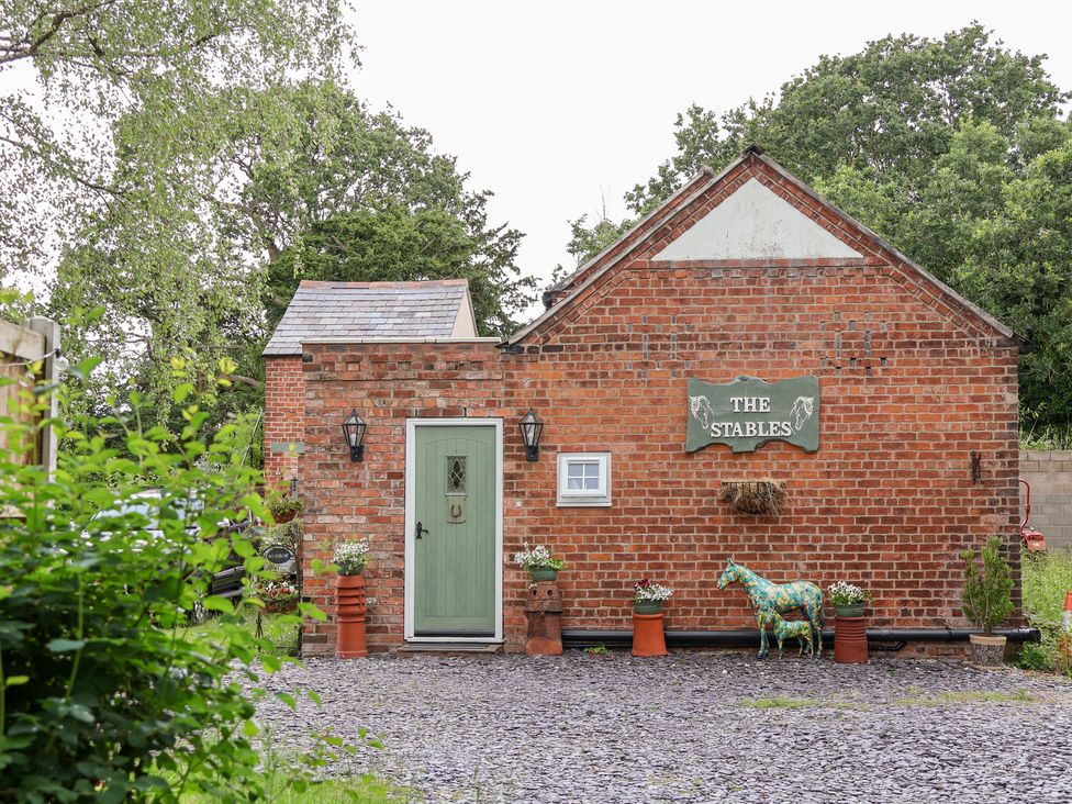 A building with a green door and sign at The Stables in Chester