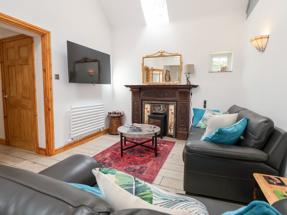 A living room with a television and a fireplace at The Stables in Chester