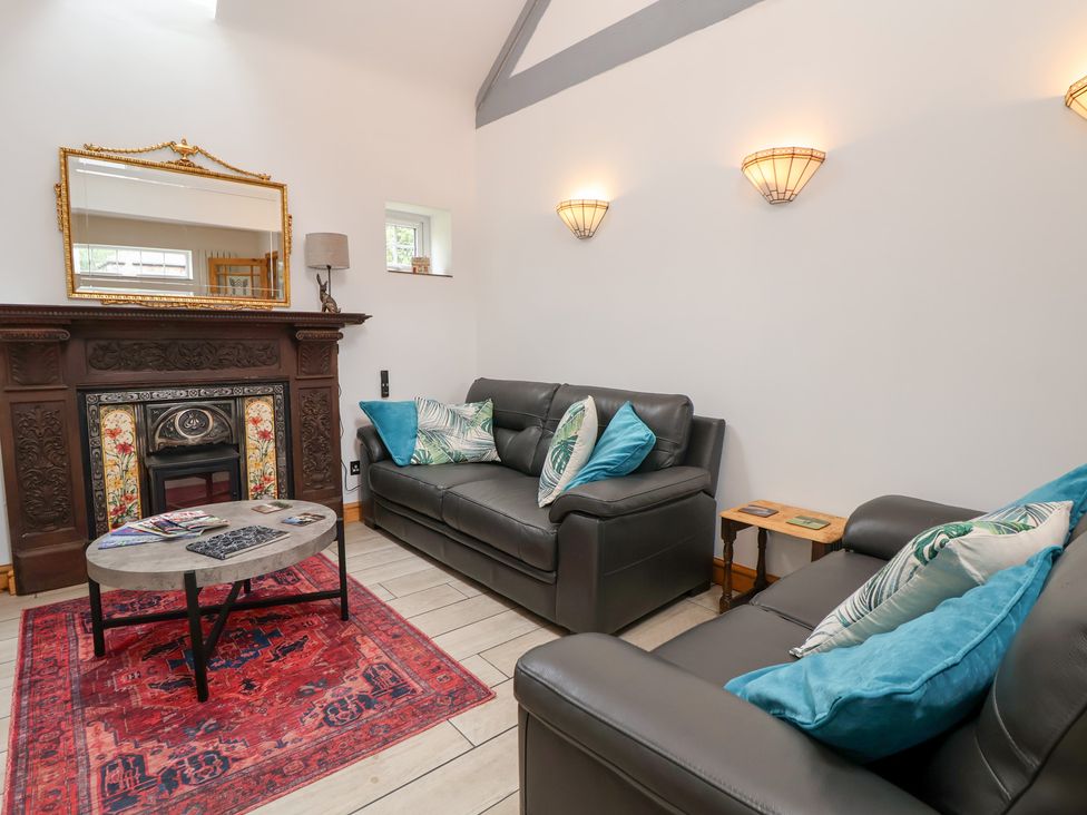 A living room with a fireplace and two sofas at The Stables in Chester