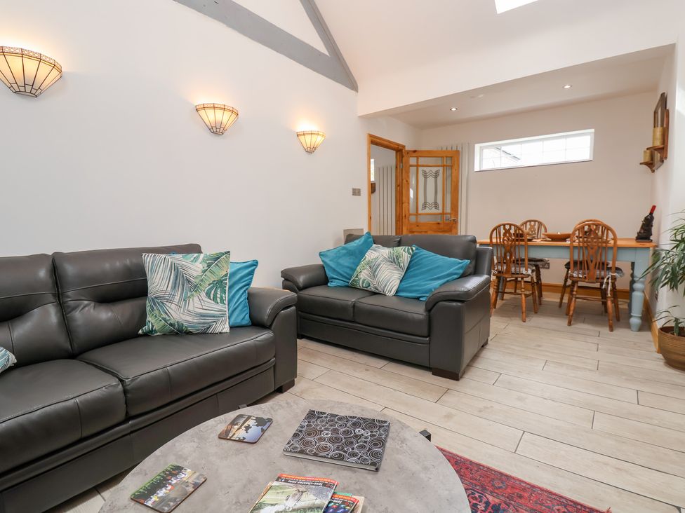A living room with two sofas and a dining area at The Stables in Chester