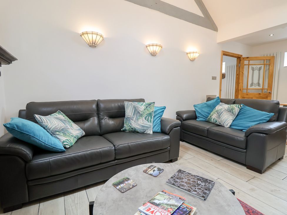 A living room with two sofas and a table at The Stables in Chester