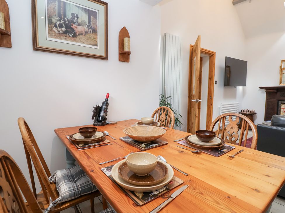 A dining room with a table set for meals at The Stables in Chester