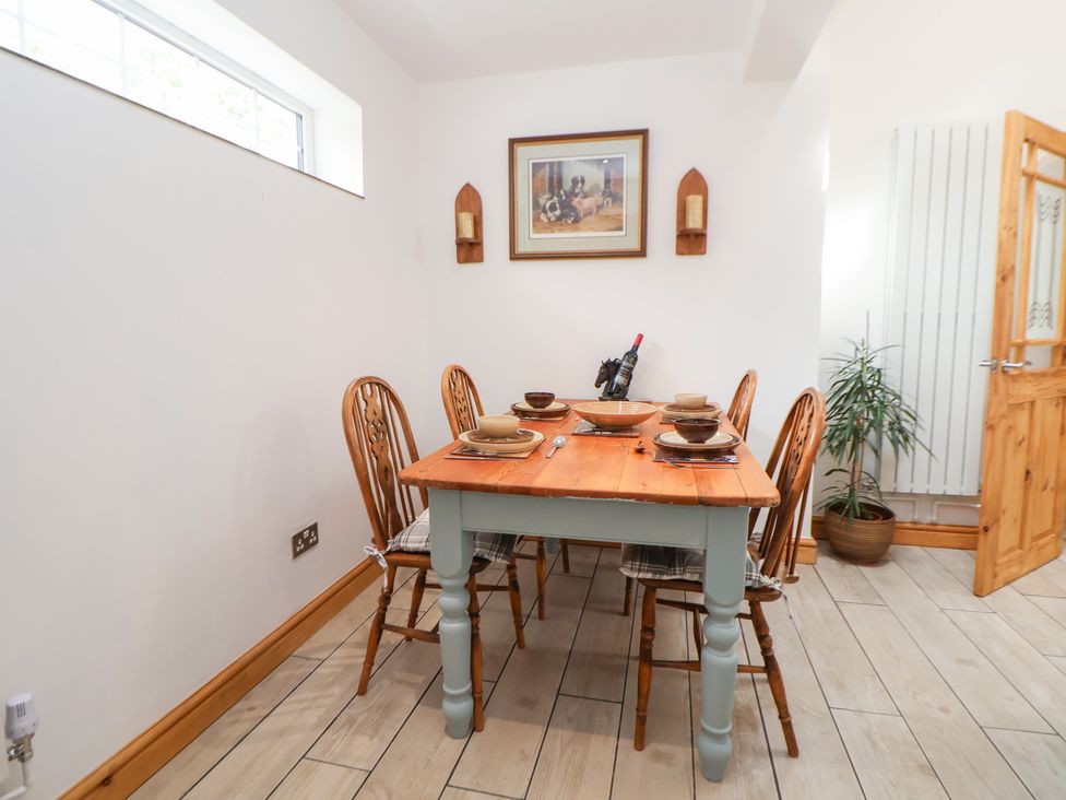 A dining room with a wooden table and chairs at The Stables in Chester