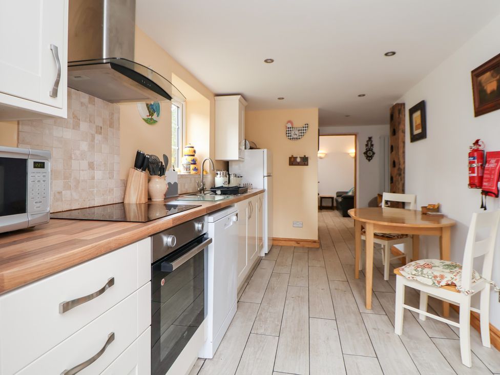 A kitchen with appliances and dining table at The Stables Chester