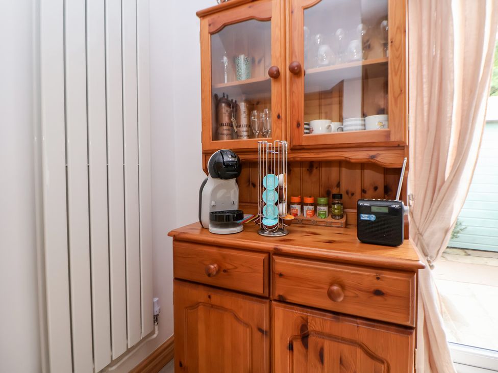 A kitchen corner with cabinets, coffee machine, and radio at The Stables Chester