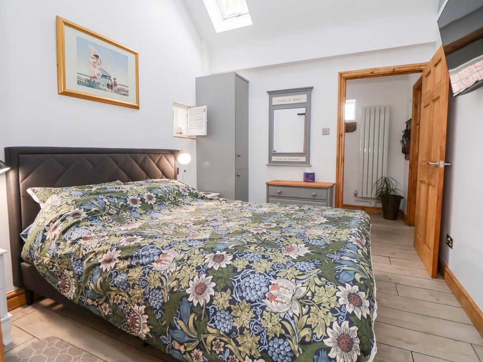 A bedroom with a bed and wardrobe at The Stables in Chester