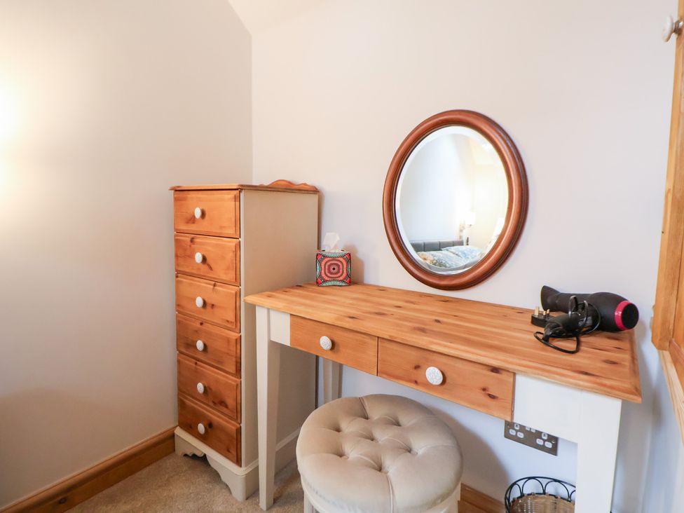 A dressing area with a mirror and hairdryer at The Stables in Chester