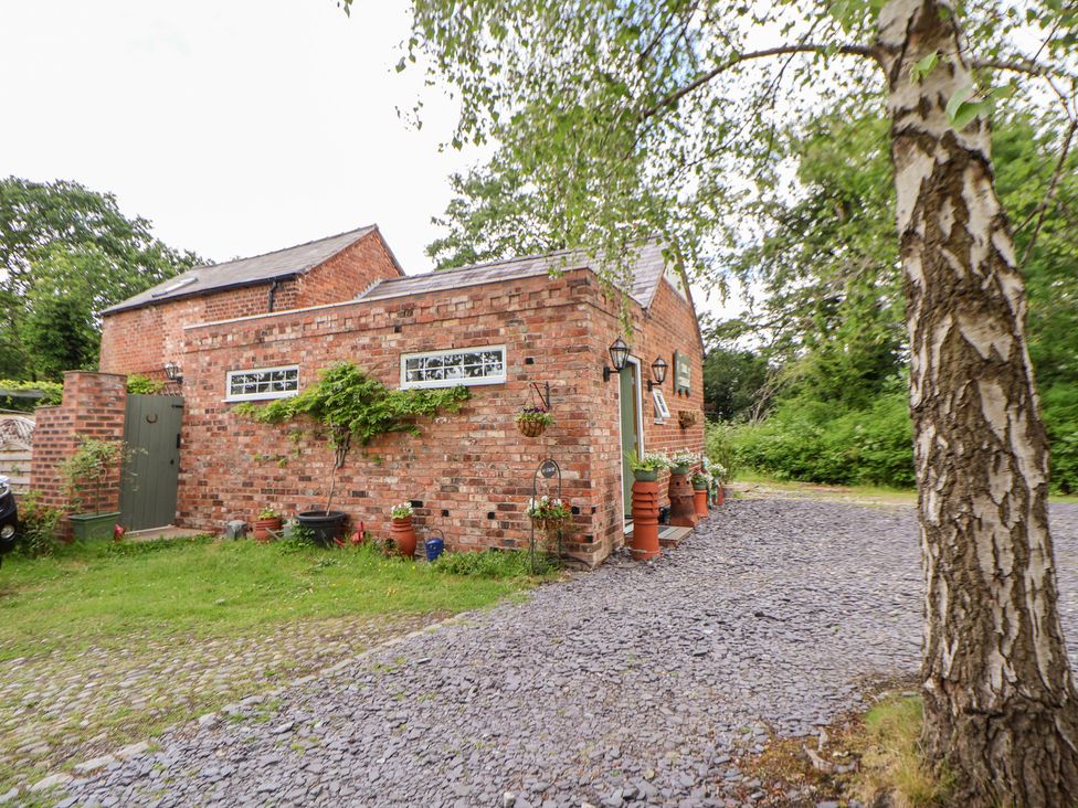 An exterior view of a brick building with a driveway at The Stables in Chester