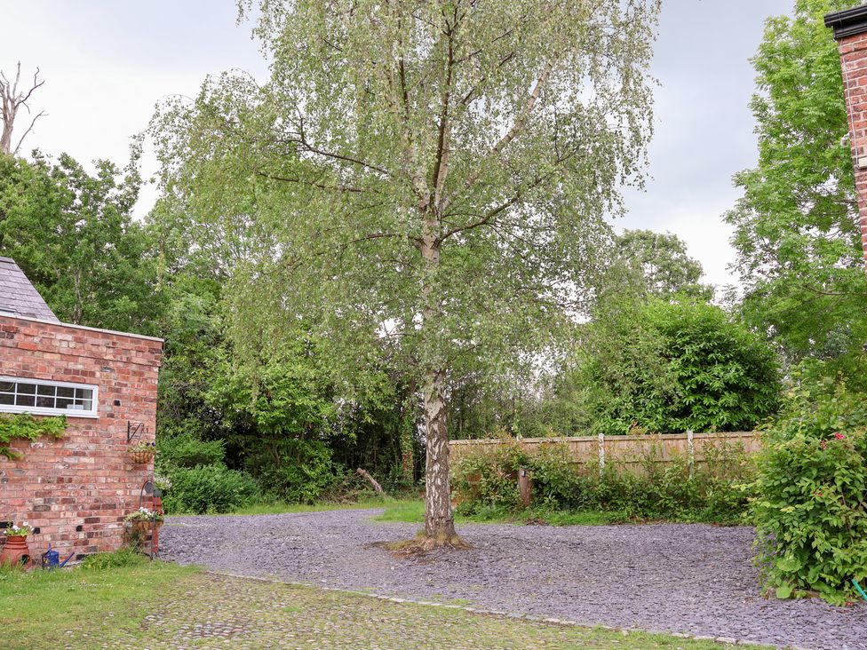 A garden area with a tree and gravel pathway at The Stables in Chester