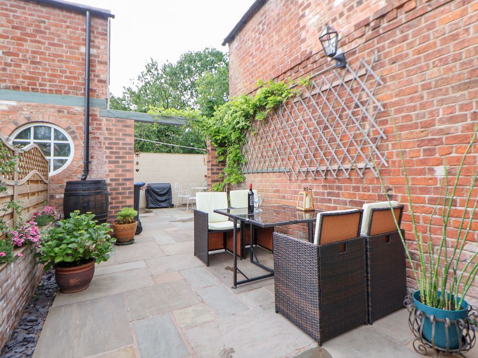 An outdoor patio area with seating and planters at The Stables in Chester