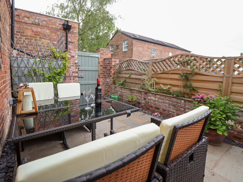 A patio area with table and chairs at The Stables in Chester