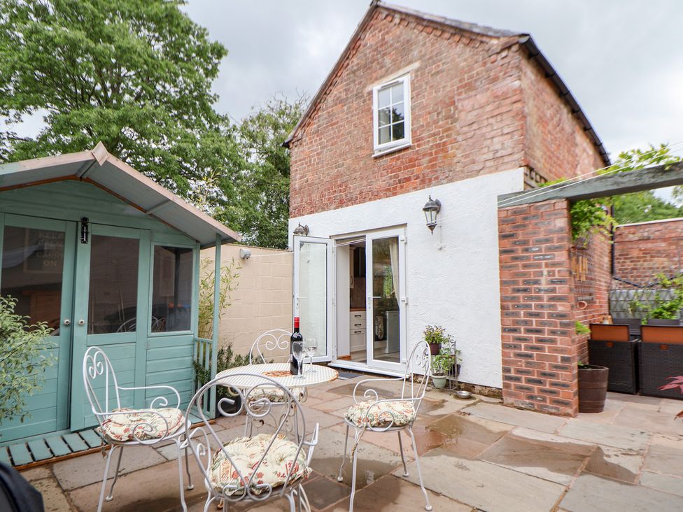 A garden with outdoor furniture and a shed at The Stables Chester