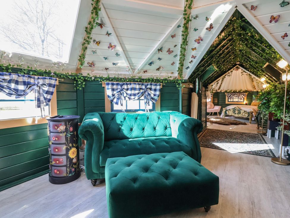 A living room with a sofa and ottoman at Applejacks Orchard in Holywell