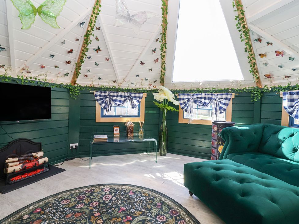A living room with a sofa and television at Applejacks Orchard in Holywell