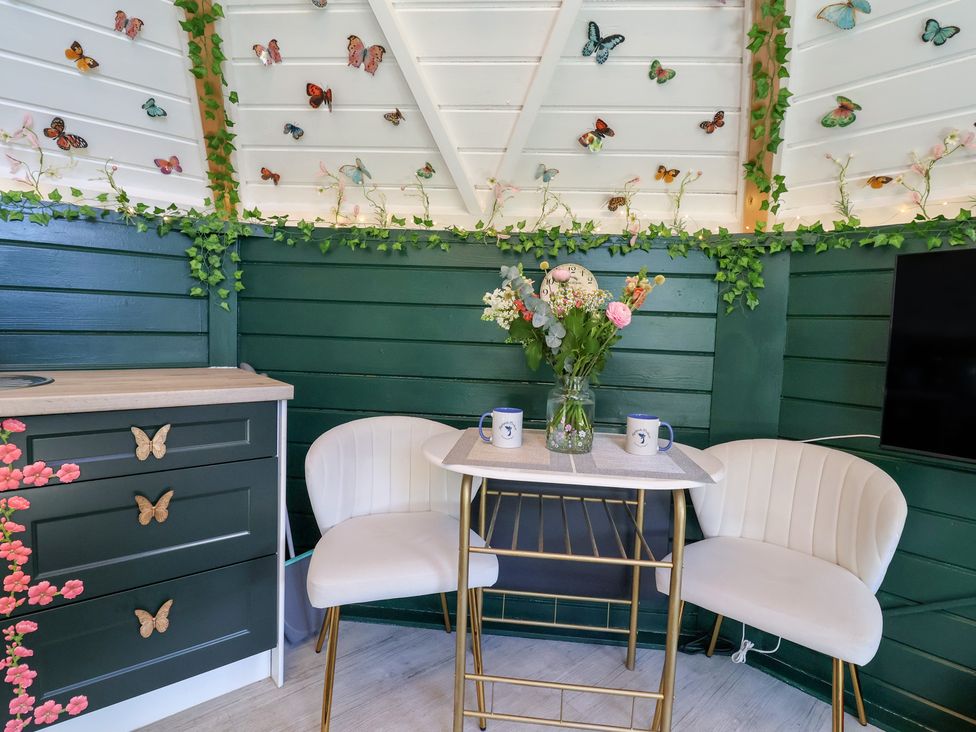 A seating area with a table and chairs at Applejacks Orchard in Holywell