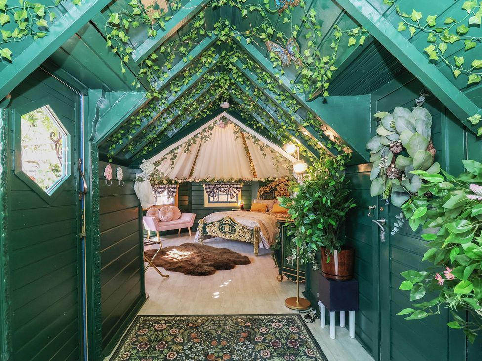 A bedroom with a bed and plants at Applejacks Orchard in Holywell