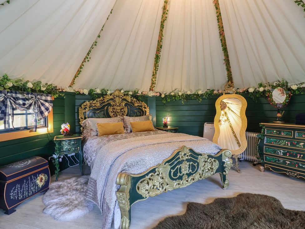 A bedroom with a bed and vintage furniture at Applejacks Orchard in Holywell