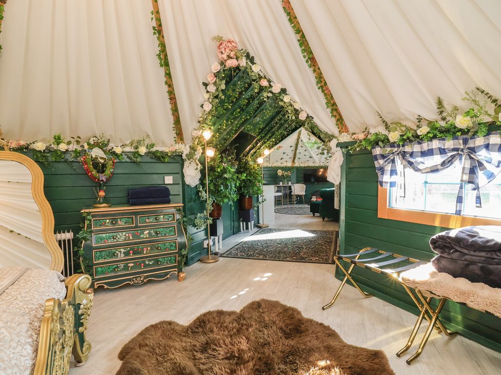 A bedroom with decorative plants and a chest of drawers at Applejacks Orchard in Holywell
