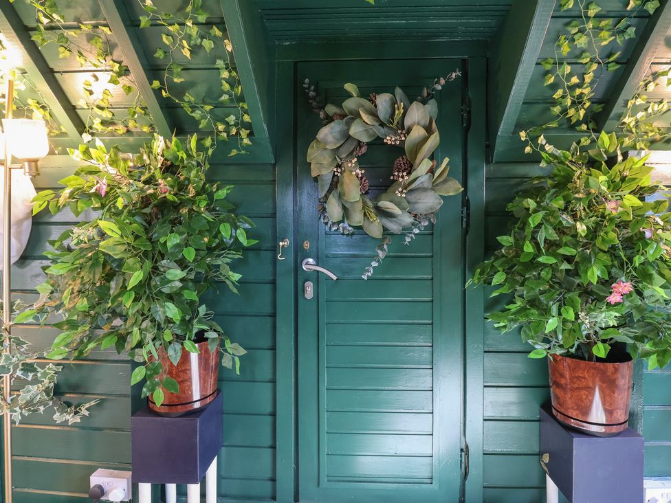 An entrance with a door, plants, and a wreath at Applejacks Orchard Holywell