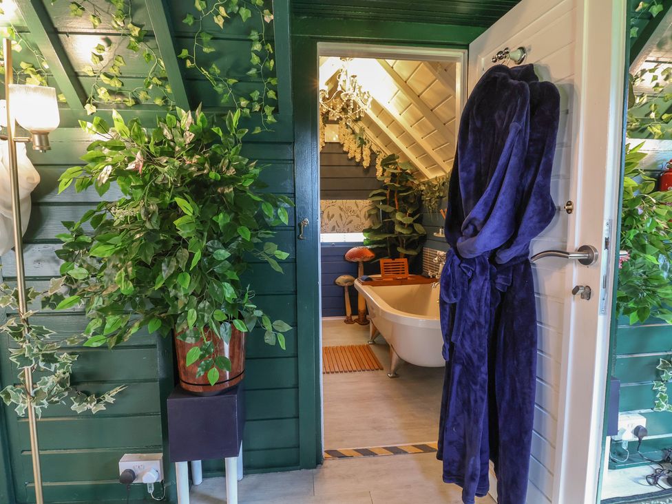 A bathroom with a bathtub and plants at Applejacks Orchard in Holywell
