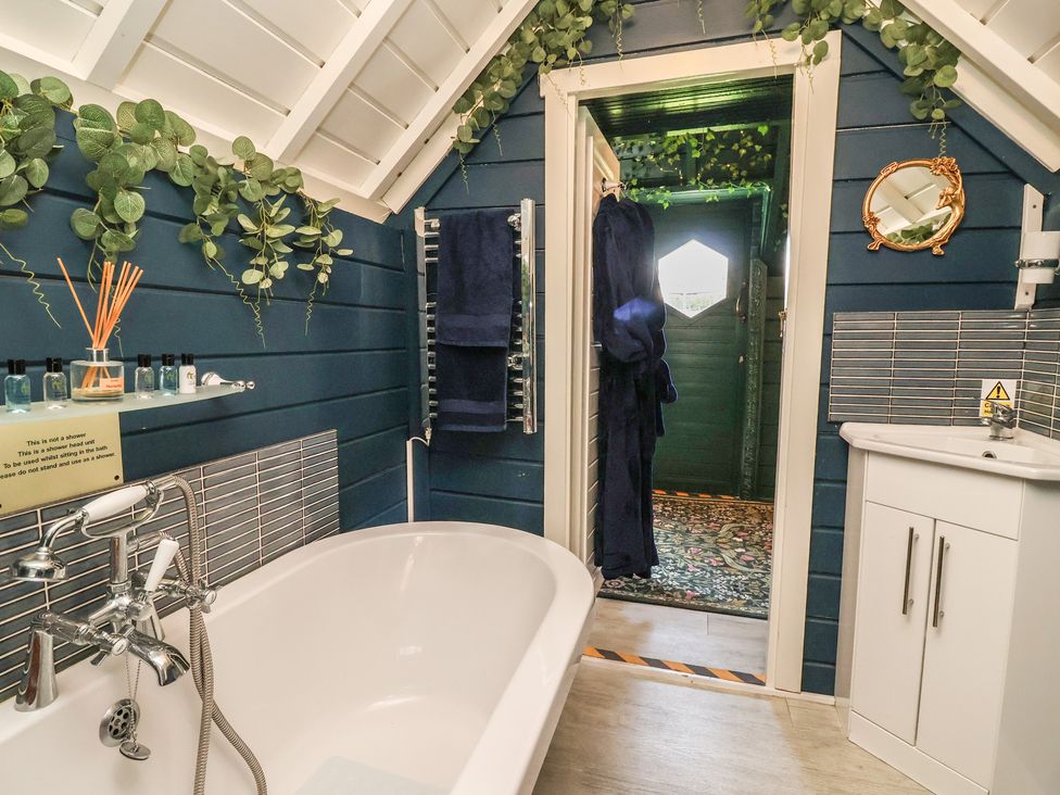 A bathroom with a bathtub and vanity at Applejacks Orchard in Holywell