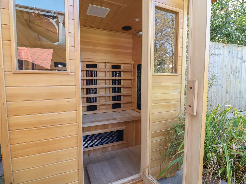 A sauna with wooden walls and benches at Applejacks Orchard in Holywell