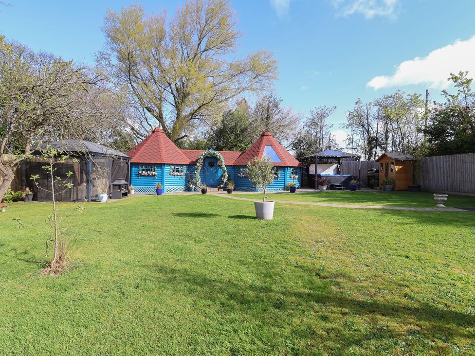 A garden with a blue shed and seating areas at Applejacks Orchard in Holywell