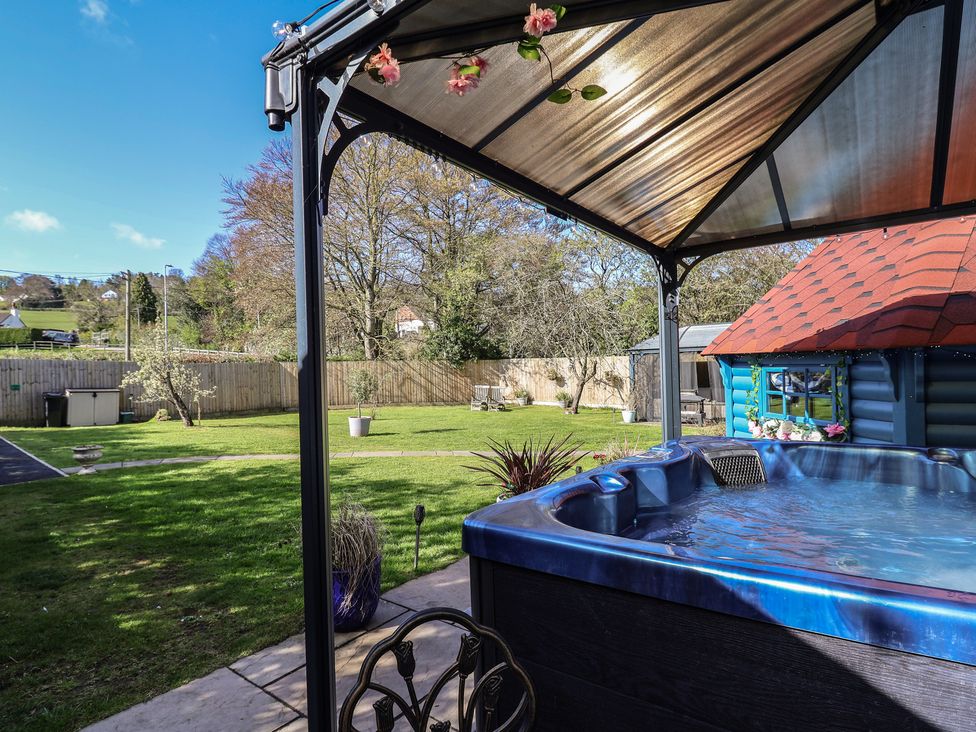 A garden with a hot tub and gazebo at Applejacks Orchard in Holywell
