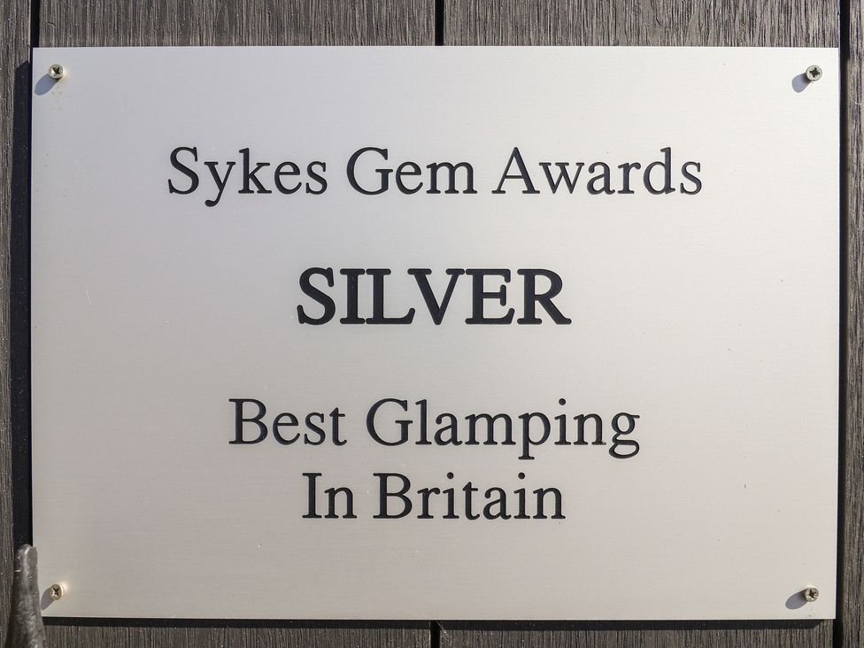 A sign indicating an award for best glamping at Applejacks Orchard in Holywell