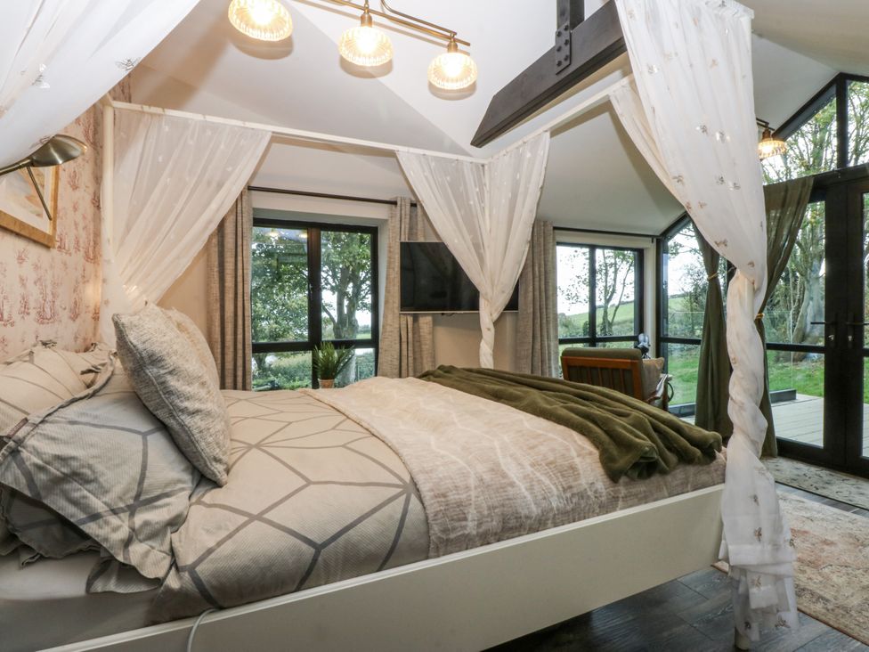 A bedroom with a bed and windows at Windyridge in Gwaenysgor, near Prestatyn