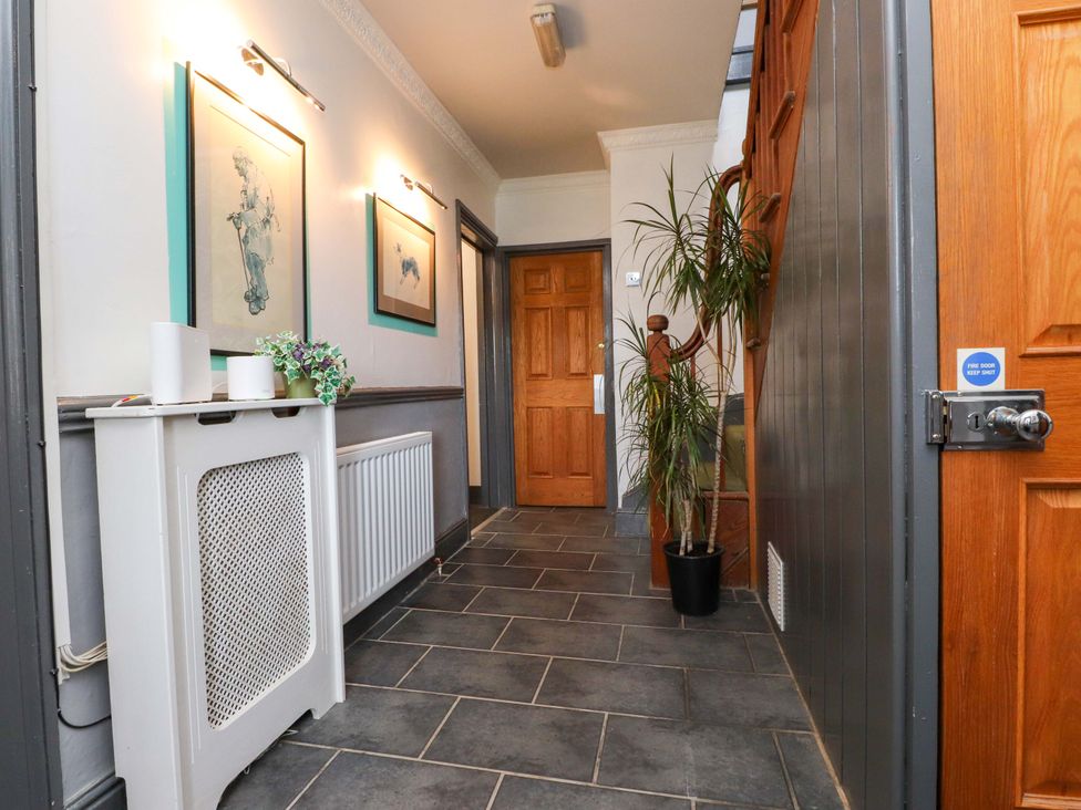 A hallway with a staircase and artwork at Mallards Rest in Llandwrog near Bontnewydd, Gwynedd