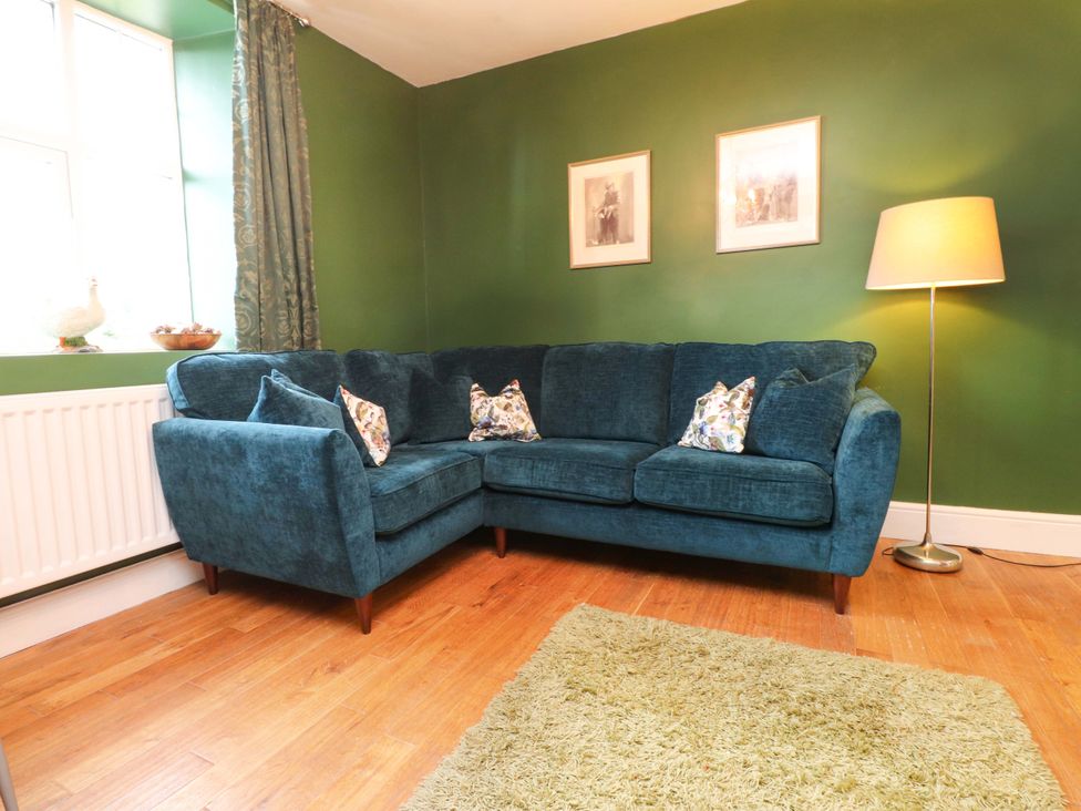 A living room with a sofa and lamp at Mallards Rest in Llandwrog near Bontnewydd, Gwynedd