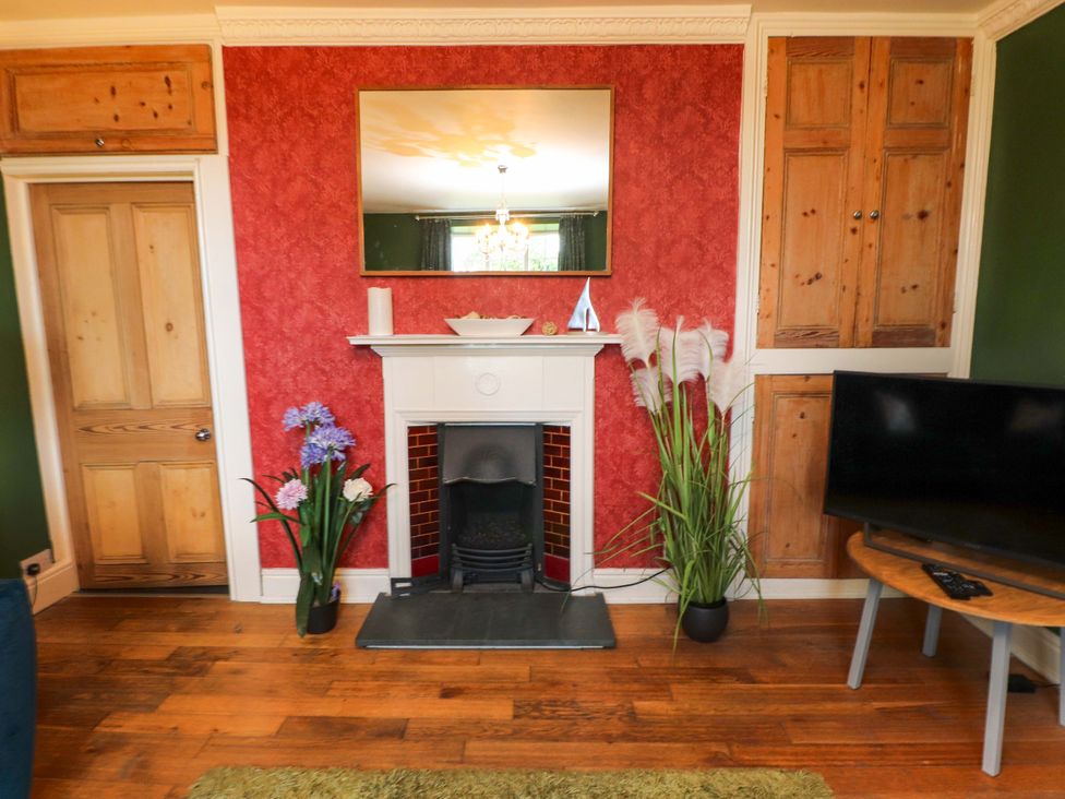 A living room with a fireplace and television at Mallards Rest Llandwrog near Bontnewydd Gwynedd