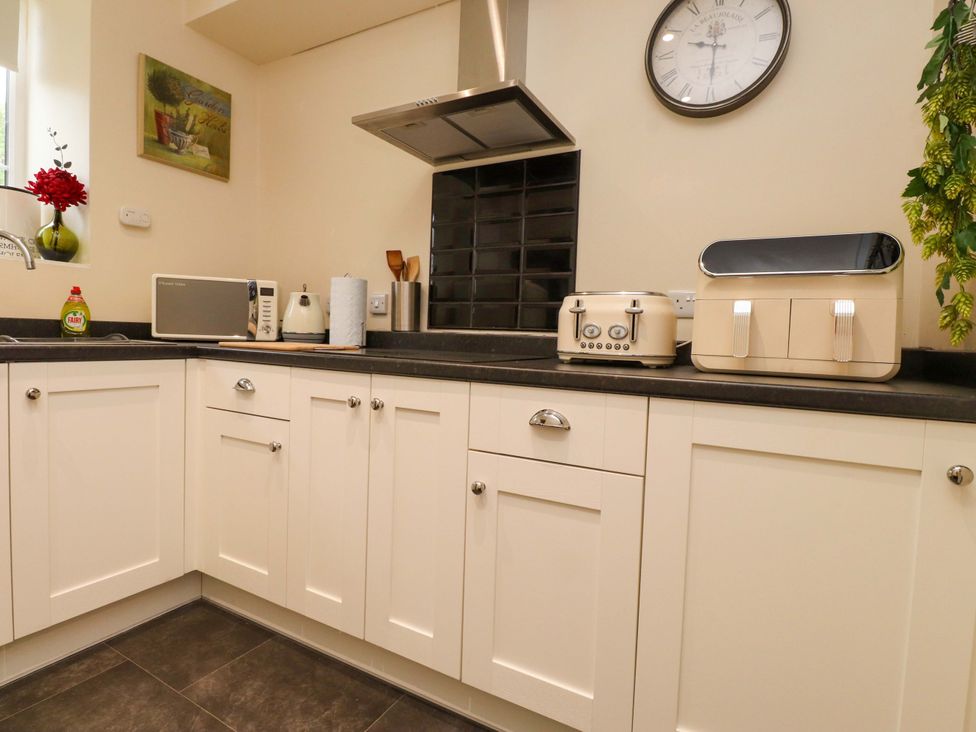 A kitchen with cabinets and appliances at Mallards Rest in Llandwrog near Bontnewydd, Gwynedd
