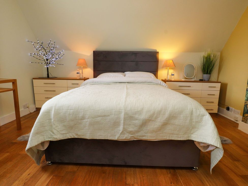 A bedroom with a bed and nightstands at Mallards Rest in Llandwrog near Bontnewydd, Gwynedd