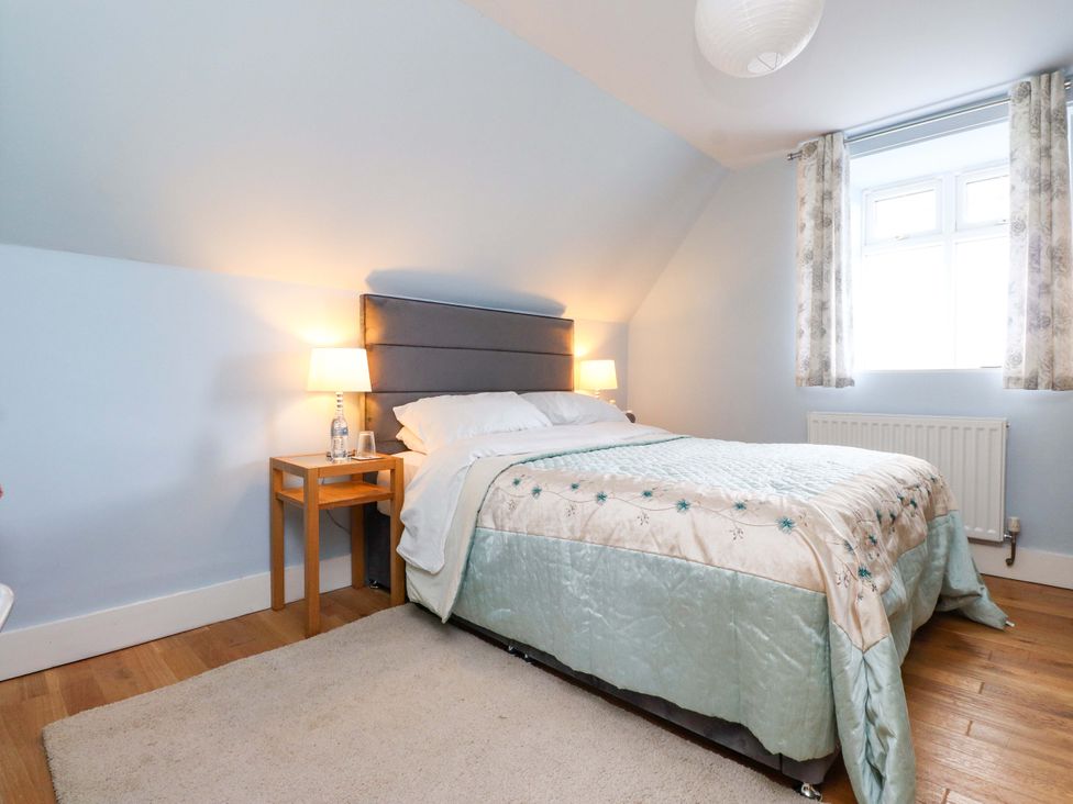 A bedroom with a bed and bedside table at Mallards Rest in Llandwrog near Bontnewydd, Gwynedd