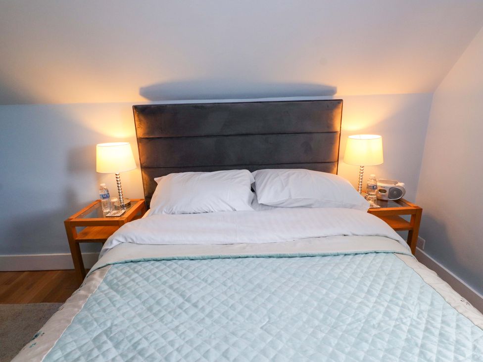 A bedroom with a bed and bedside table at Mallards Rest in Llandwrog near Bontnewydd, Gwynedd