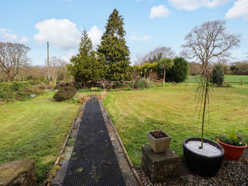 A garden with a pathway and trees at Mallards Rest Llandwrog near Bontnewydd Gwynedd